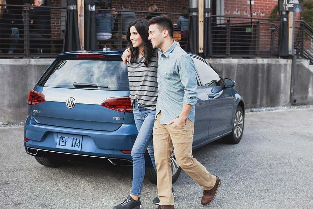 Couple walking past 2018 Volkswagen Golf