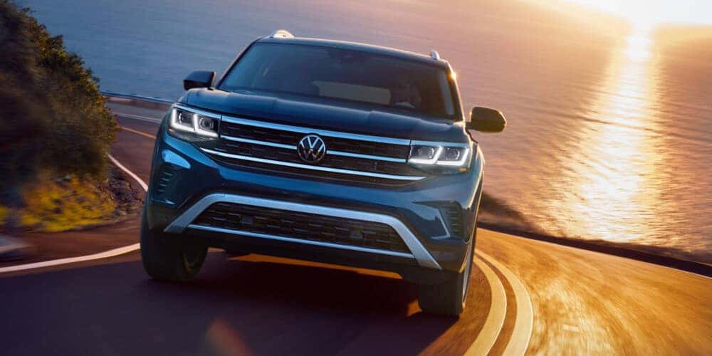 2021 Volkswagen Atlas driving down road with sunset