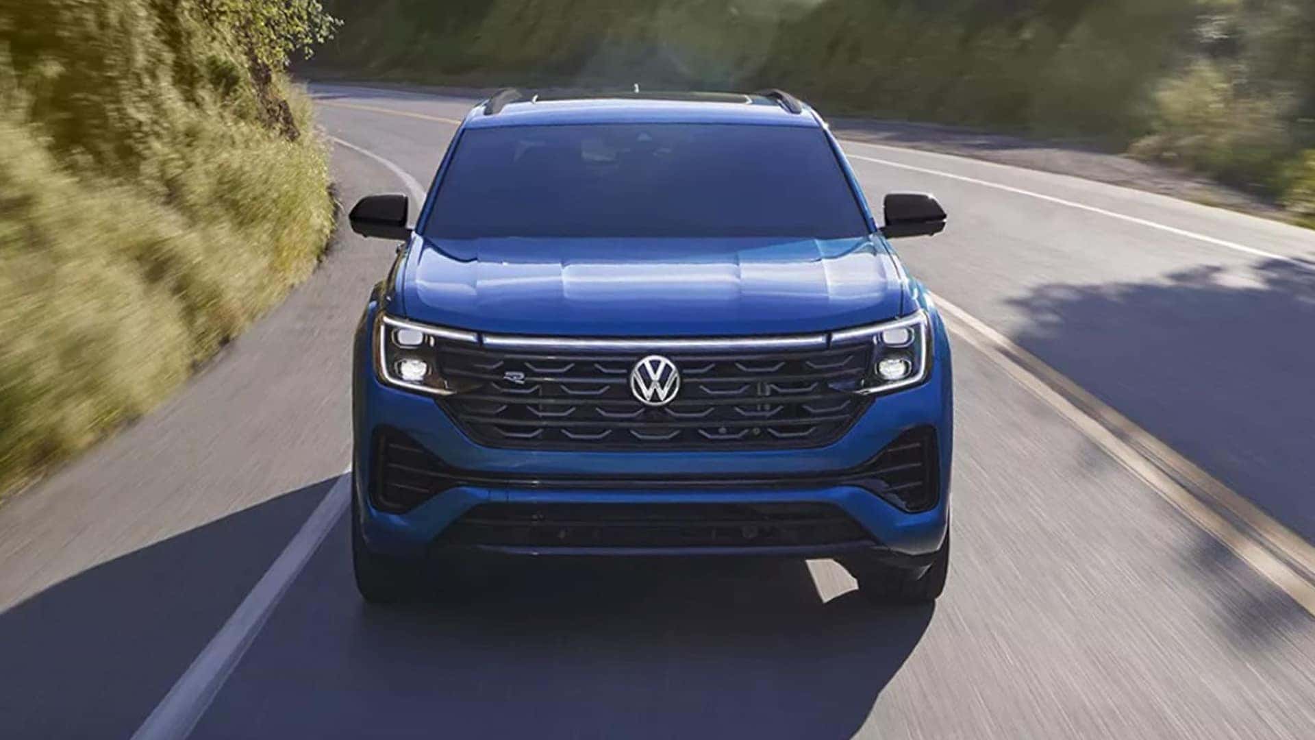 blue 2025 atlas cross sport driving on road
