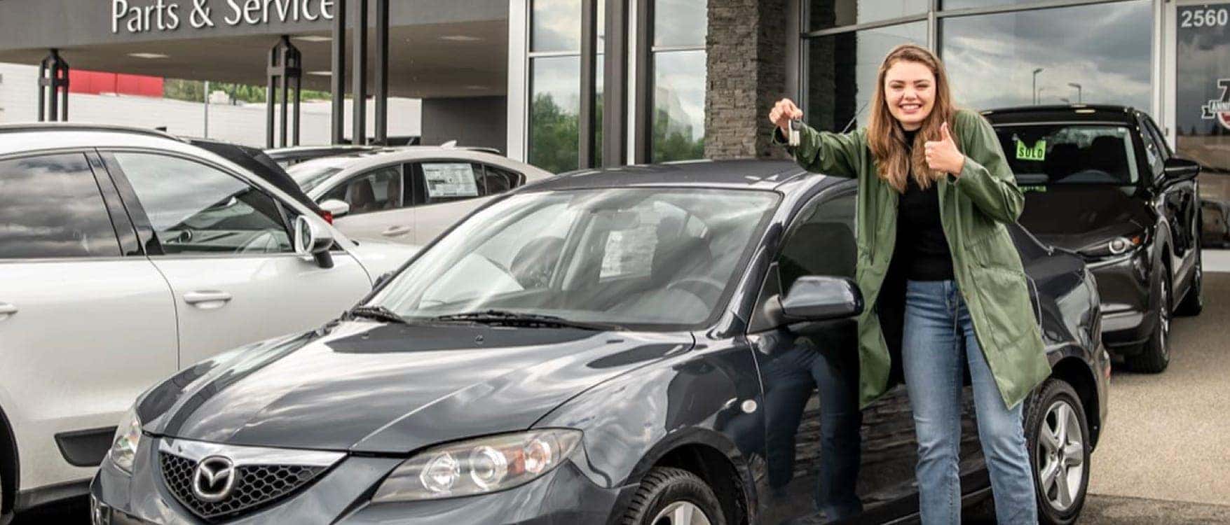 A happy client outside of the August Mazda dealership