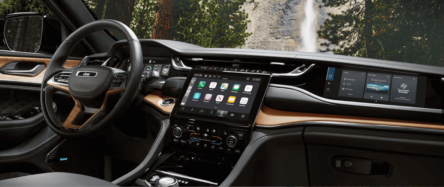 Interior of the 2025 Jeep Grand Cherokee featuring wood accents, digital displays, and a large central touchscreen.