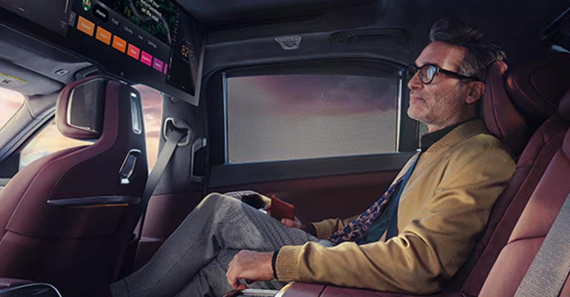 Man in backseat watching screen 2025 BMW 7 Series Sedan