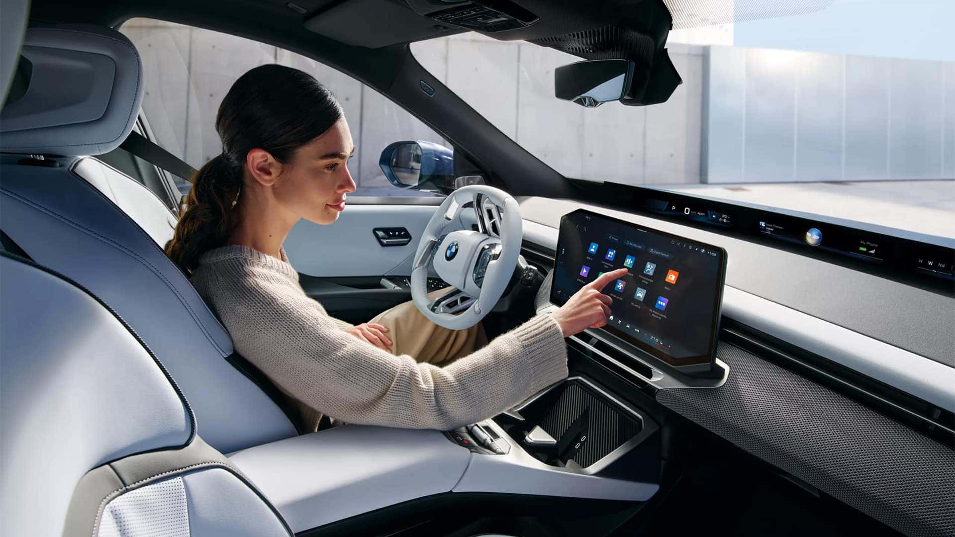 Woman using touchscreen inside of 2026 BMW iX3