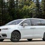 The 2021 Chrysler Pacifica Hybrid parked in front of trees.