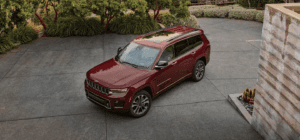 A red 2021 Jeep Grand Cherokee L parked outside of someones home.