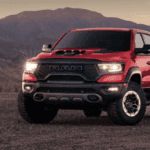 Three different RAM trucks parked on a dirt road.