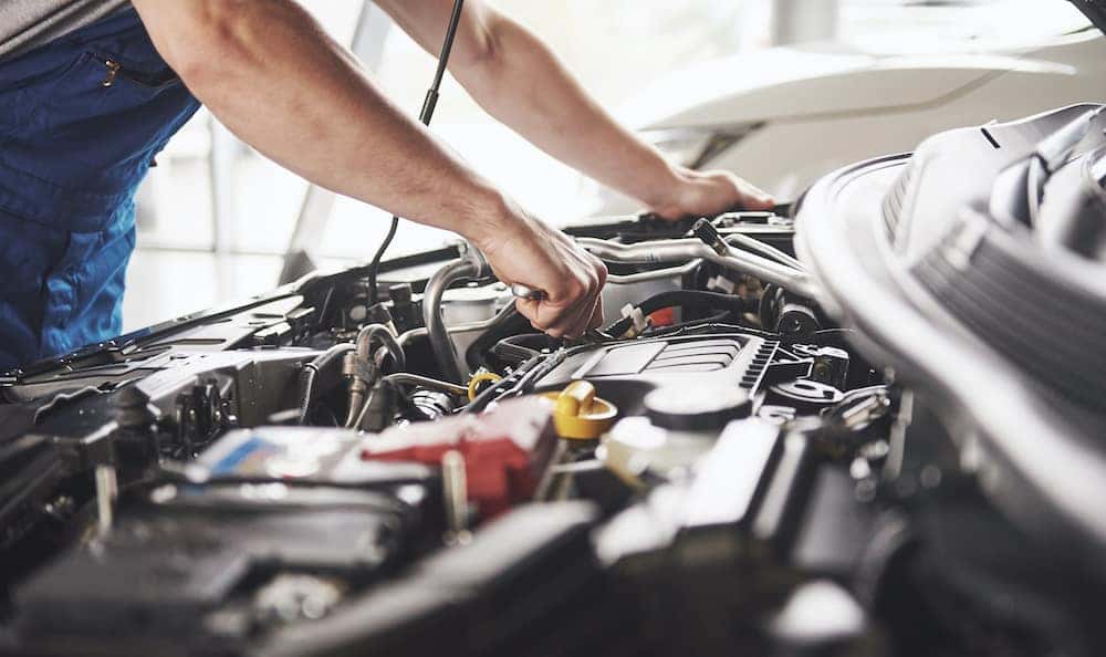 Car Maintenance FAQs Contemporary CDJR Mechanic Working on Car Engine