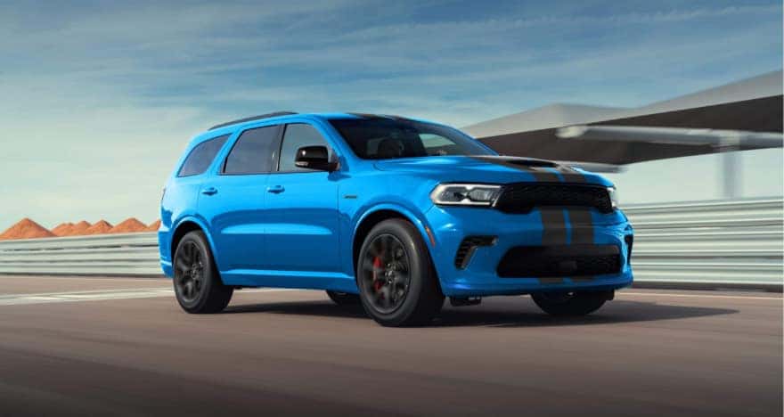 A light blue Dodge Durango driving on a racetrack.