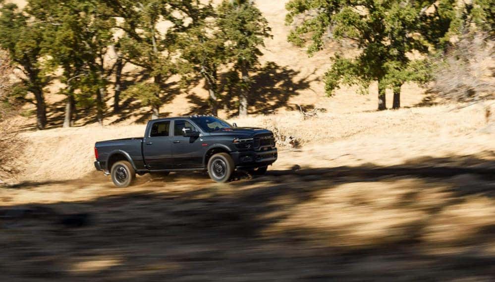 A dark-colored RAM 2500 driving off-road.