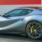 Ferrari 812 Competizione parked near a garage