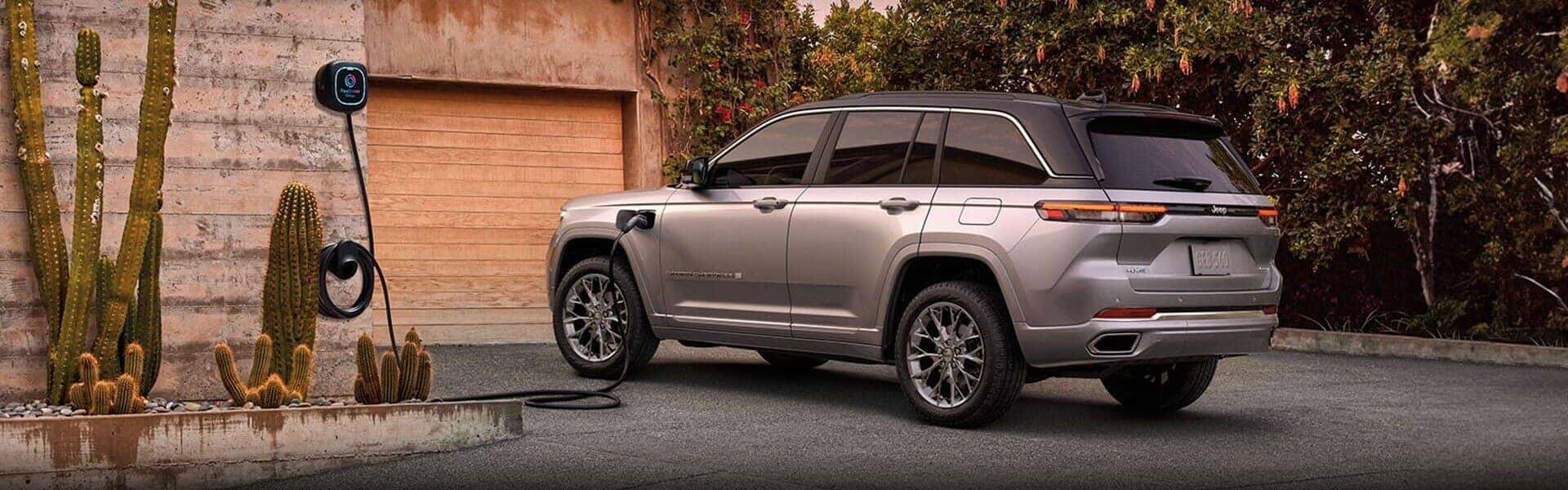2024 Jeep Grand Cherokee 4xe Charging In Driveway, Next To A Cactus