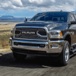 2018 RAM 2500 towing a trailer at full speed along an open road.