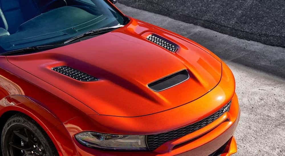 A close up of the hood of an orange 2023 Dodge Charger SRT Hellcat Redeye is shown.