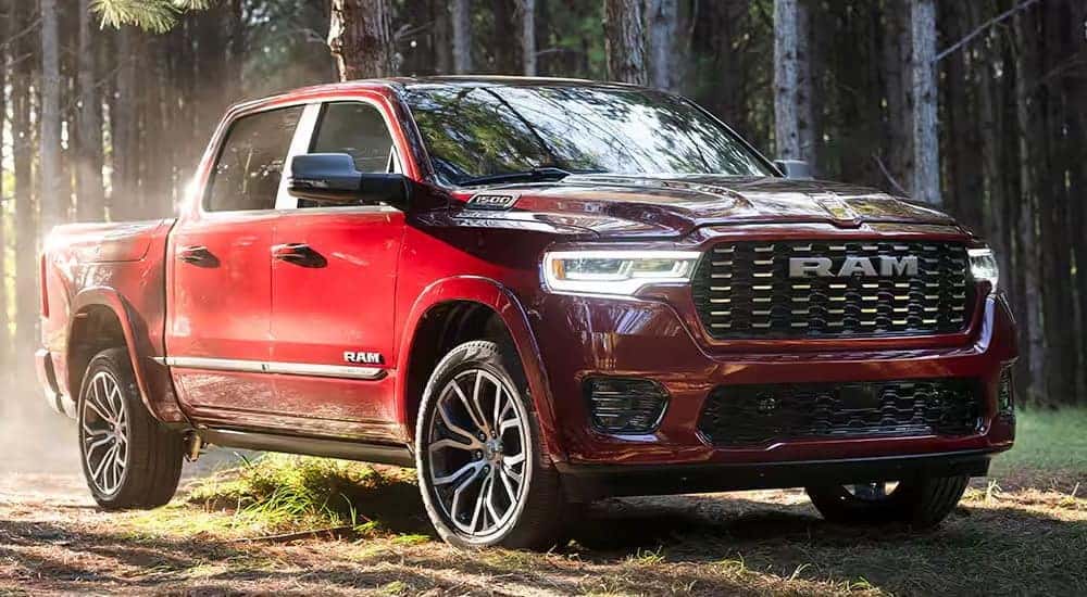 A red 2025 Ram 1500 is shown parked in a forest.