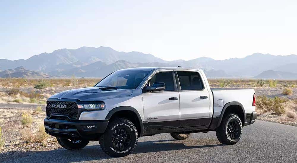 A white 2025 Ram 1500 Rebel is shown parked and angled left.