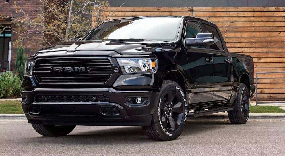 A black 2024 Ram 1500 is shown parked near a building.