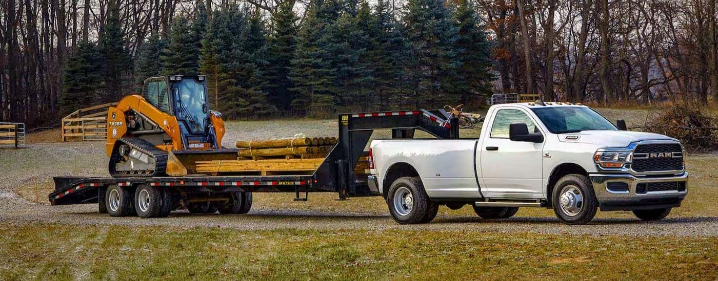 A white 2024 Ram 3500 is shown parked with an attached trailer.
