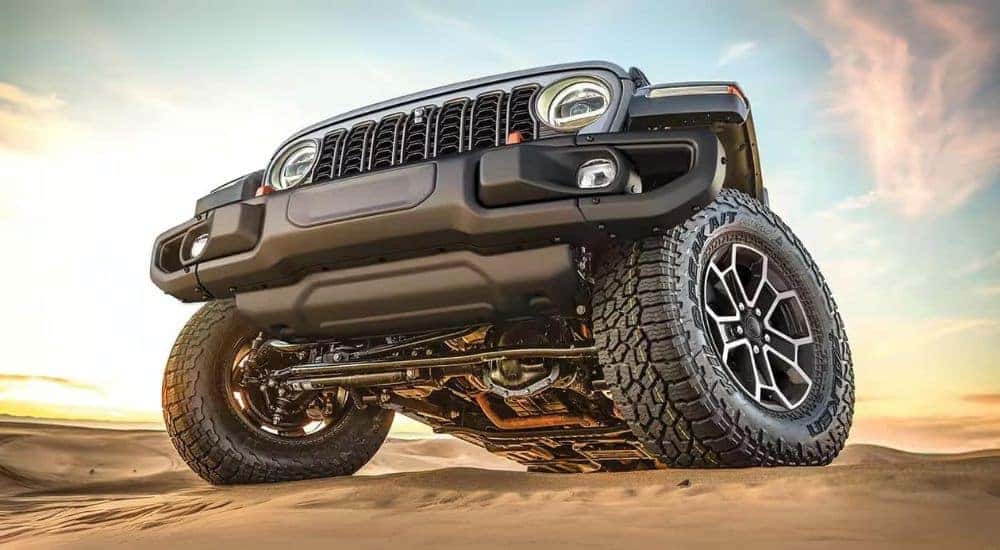 A grey 2024 Jeep Gladiator is shown from a low angle.