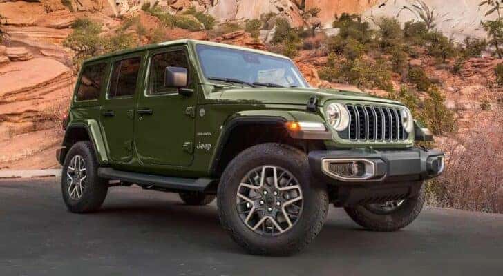 A green 2024 Jeep Wrangler Sahara is shown parked after viewing a Jeep Wrangler for sale near Louisville.