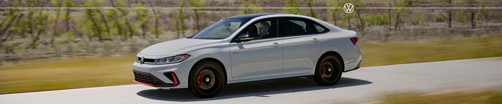 Volkswagen Jetta GLI Autobahn Black Package exterior in Pure Gray on a paved mountain road