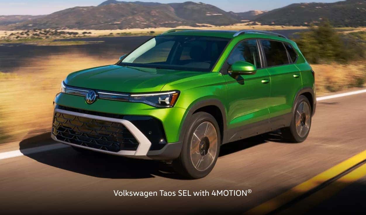 Volkswagen Taos SEL with 4MOTION® is driving on a scenic, sunny road.