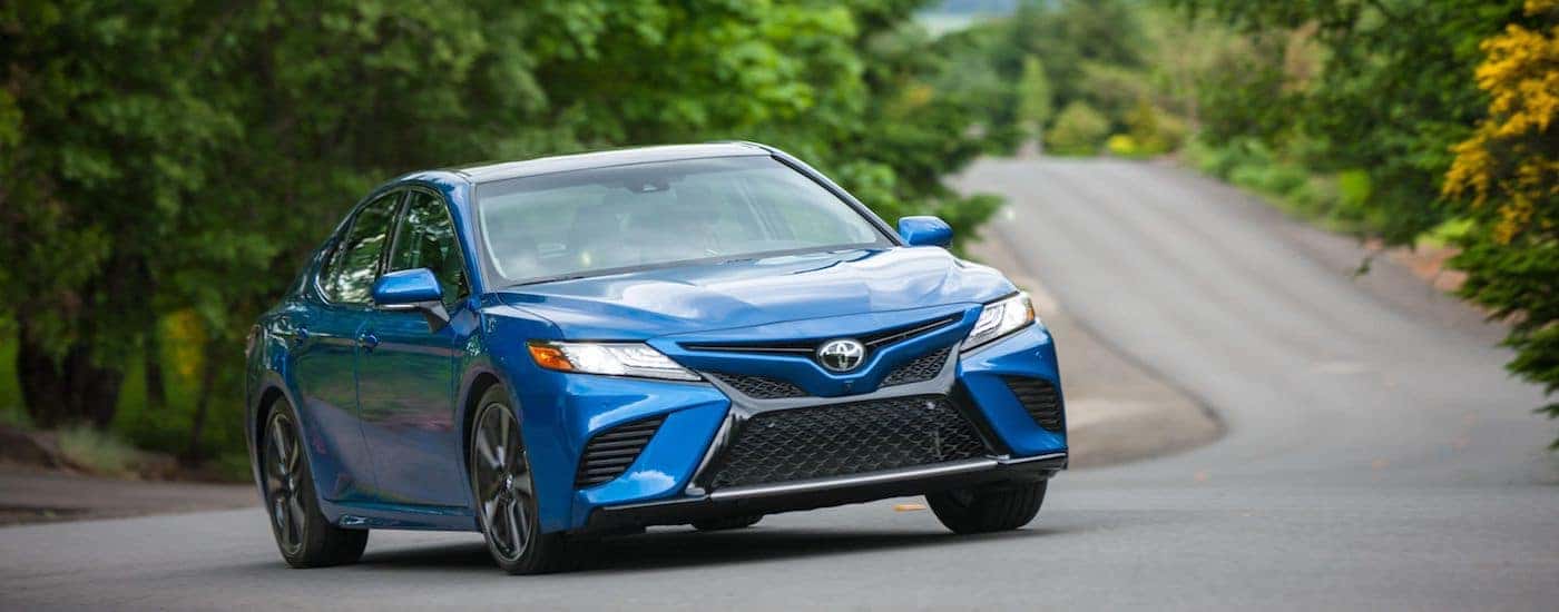 Blue 2018 Toyota Camry on a winding country road