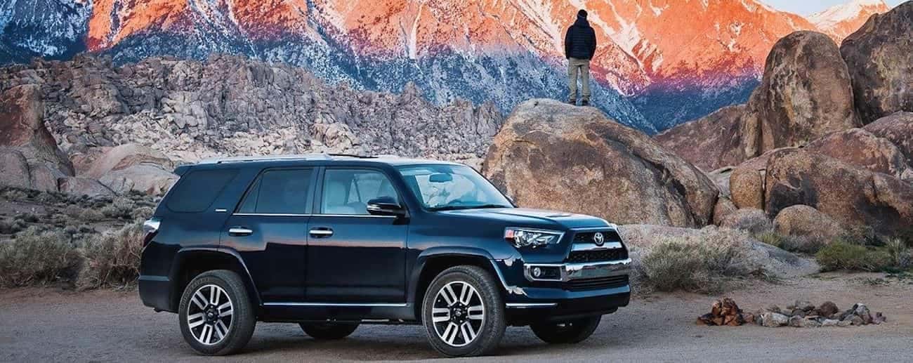 A black 2019 2019 Toyota 4Runner parked next to a campfire on a wilderness camping trip