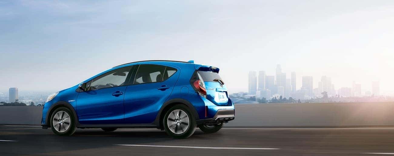 A blue 2019 Toyota Prius cruises an empty freeway outside Cincinnati in the early morning