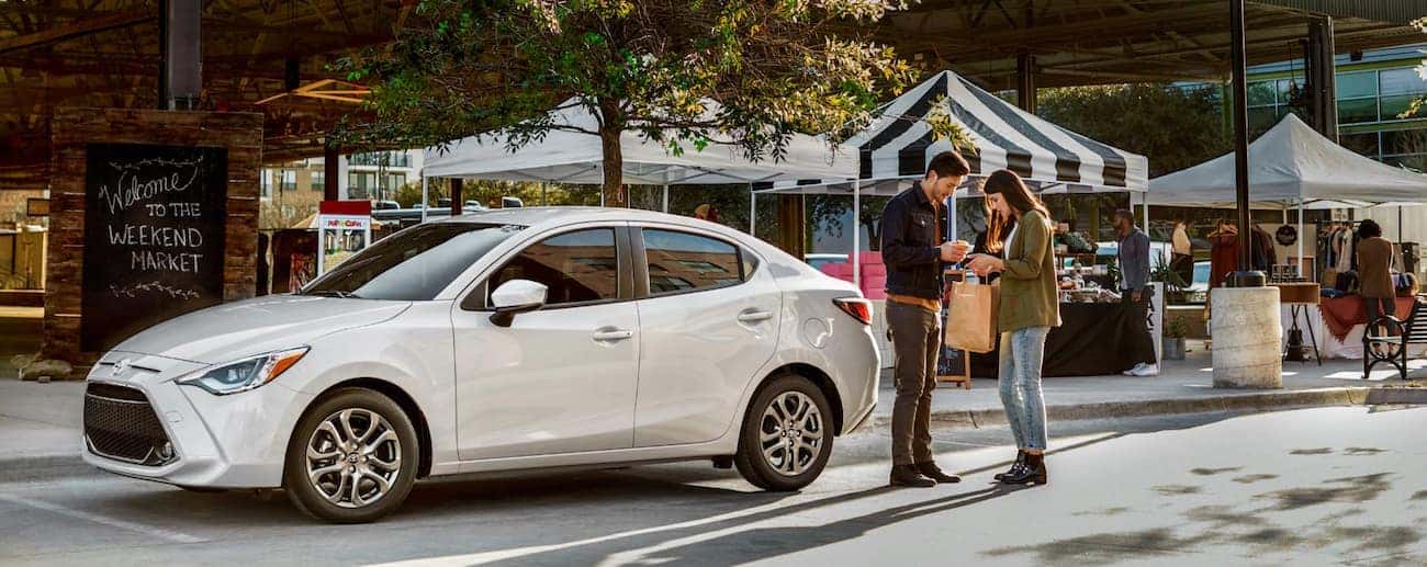 A young couple parks their white 2019 Toyota Yaris to go shopping