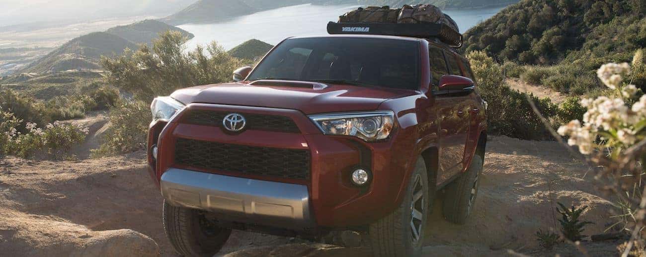 A deep red 2019 Toyota 4runner climbs a steep pile of rocks