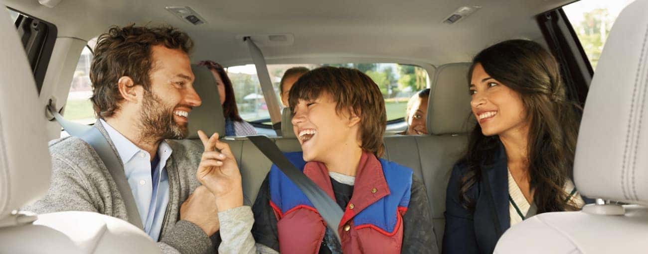 A family sits and laughs in the backseat of a 2019 Toyota Highlander