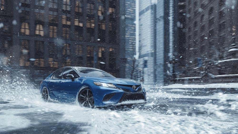2020 toyota camry awd blue exterior driving in snow