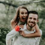 Woman smiling on man's back