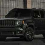 Image of a black 2019 Jeep Renegade SUV parked in front of a gate.