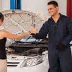 Image of a mechanic handing keys to a female car owner.