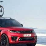 2019 Range Rover Sport in Firenze Red with bike rack and boat in background