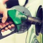 man pumping gasoline fuel in car at gas station