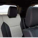 Interior rear seating with two-tone light gray and black leather trim inside a 2026 Land Rover Discovery.