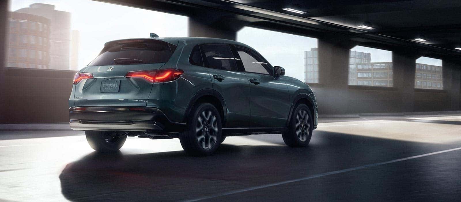 A teal Honda HR-V driving through a parking garage.