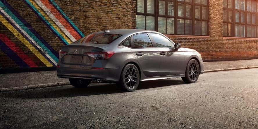 A gray 2026 Honda Civic sedan parked in front of a brick wall