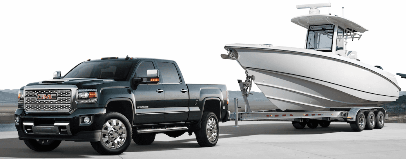 A dark colored 2019 GMC Sierra Denali HD is towing a boat near Atlanta, GA.