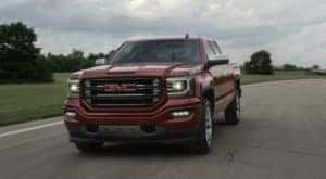 A burgundy 2017 GMC Sierra is driving on the highway outside Atlanta, GA.