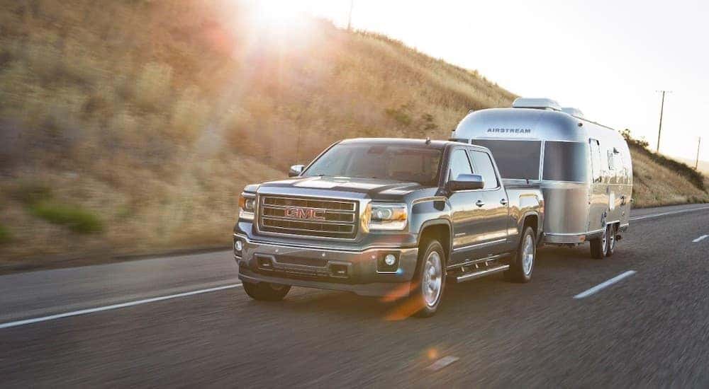 A grey 2015 GMC Sierra, popular among used trucks for sale, is towing an Airstream outside Atlanta, GA.