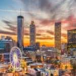 A picture of the Atlanta, GA skyline lit up during a sunset.