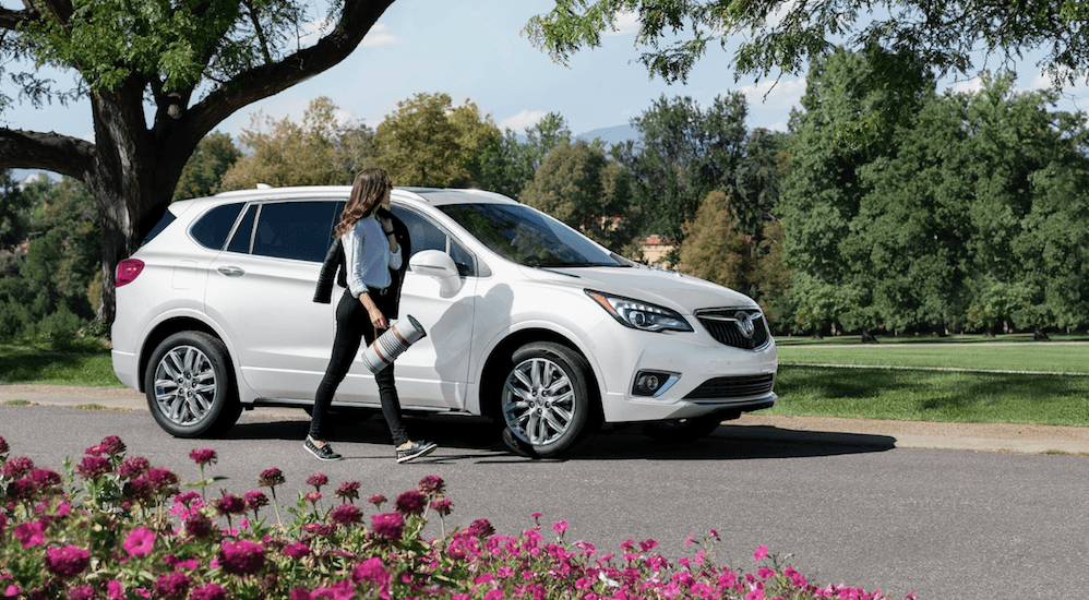 A white 2020 Buick Envision, which is a popular model that comes up when you search, 'Buick dealerships near me,' is parked at a park.
