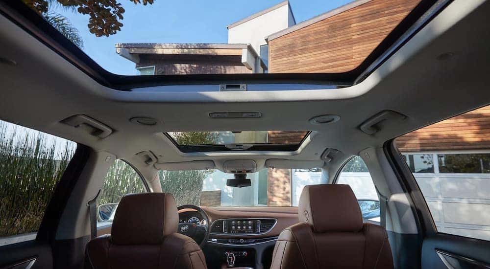 An interior view of the 2020 Buick Enclave Avenir's front and back row moon roof is shown.