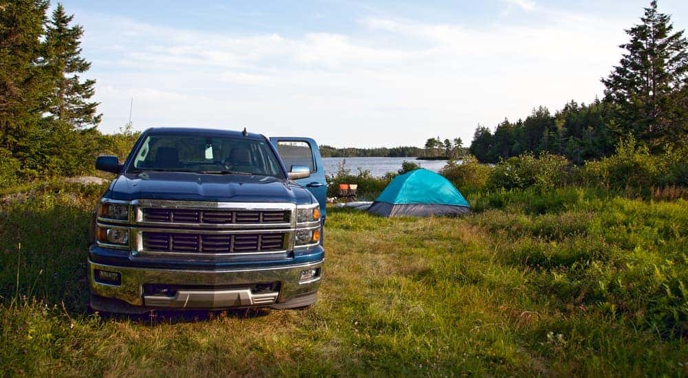 A campsite is set up next to a blue truck and a lake near Atlanta, GA.