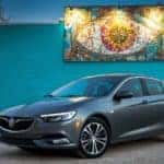 A grey 2019 Buick Regal Sportback is shown parked outside of a book store.