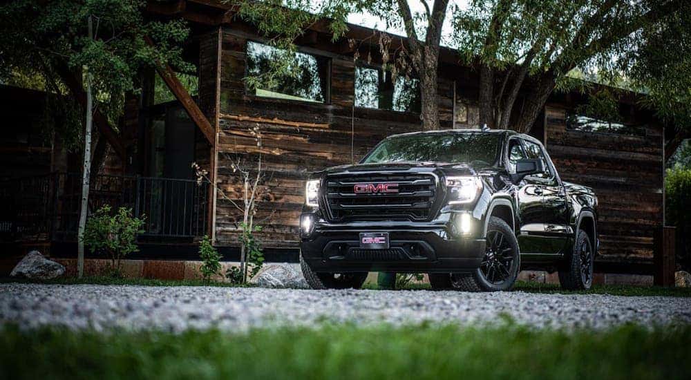 A black 2020 GMC Sierra Elevation is parked in front of a cabin.