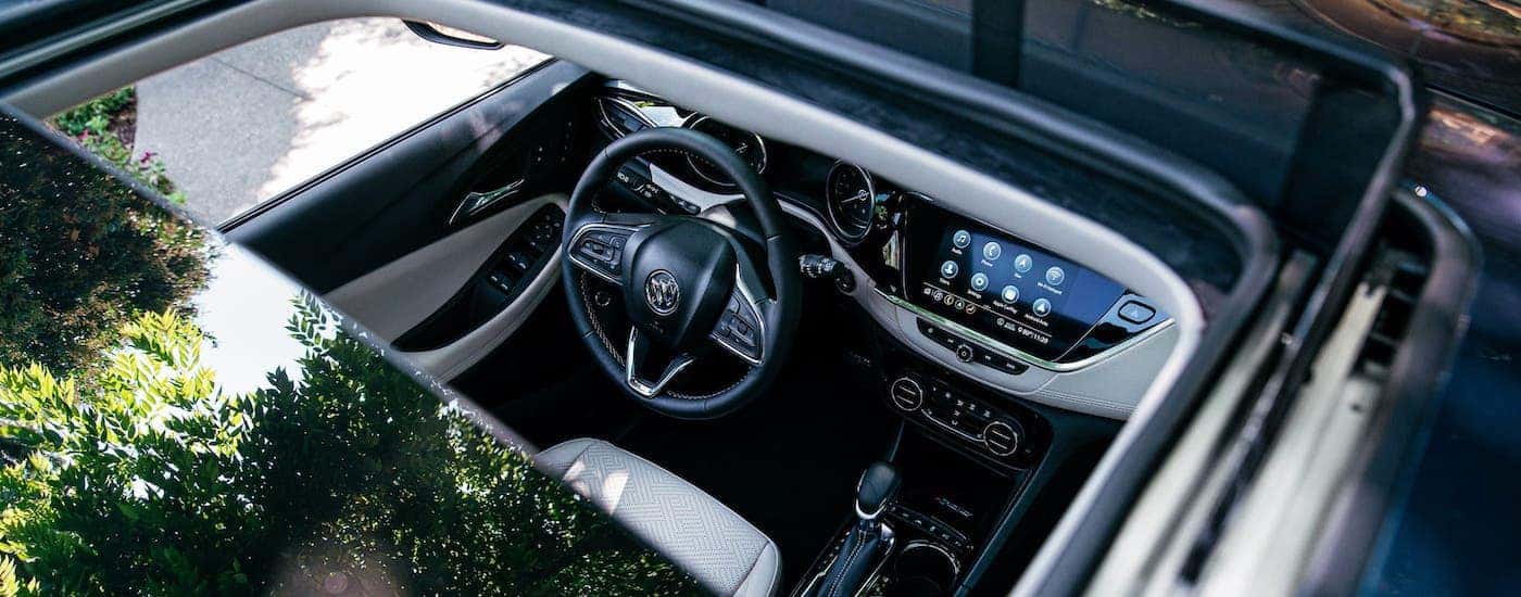 The interior of a 2020 Buick Encore GX is shown from the outside through the sunroof.